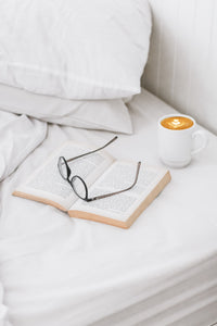 white sheet set with glasses book and coffee luna luxury